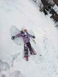 Dziewczynka robiąca aniołka na śniegu
